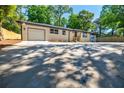 Single-story home with attached garage and large front parking pad at 3154 N Druid Hills Rd, Decatur, GA 30033
