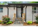 Welcoming entryway with stone steps, wooden railings, fresh plants, and a bright white front door at 3154 N Druid Hills Rd, Decatur, GA 30033