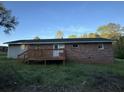 Rear exterior view of brick home featuring a wooden deck and grassy lawn at , Covington, GA 30014