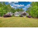 Beautifully landscaped home with a gray exterior, dormer windows, and mature trees in the background at 1080 Gaithers Rd, Mansfield, GA 30055