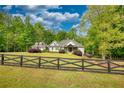 Beautiful home on large lot with black fence, surrounded by lush trees and sky at 1080 Gaithers Rd, Mansfield, GA 30055