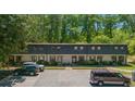 Townhouse complex showcasing a well-manicured exterior, with ample parking and lush greenery surrounding the property at 305 Stonecliff Ct, Stone Mountain, GA 30083