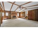 Spacious living room with a brick fireplace, wooden paneling, beamed ceiling, and neutral carpeting at 2062 Skyhawk Ln, Acworth, GA 30102