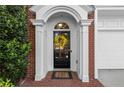A welcoming front entryway with a decorative wreath, white columns, and classic brick detailing at 4912 Waters Edge Trl, Roswell, GA 30075