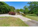 Long concrete driveway with mature trees and shrubs leading to a charming home creating a serene setting at 1170 Moseley Rd, Stockbridge, GA 30281