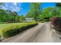 Long concrete driveway with lush landscaping leading to a charming home creating a serene approach at 1170 Moseley Rd, Stockbridge, GA 30281