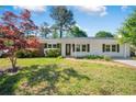 Charming house with a well-kept lawn and a mix of shrubs and trees adding to the curb appeal at 4861 Alcan Rd, Powder Springs, GA 30127