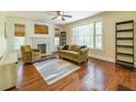 Cozy living room with hardwood floors, a fireplace, and large windows providing natural light at 5201 Skyline Dr, Stone Mountain, GA 30083