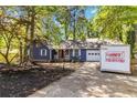 Quaint blue home with attached garage boasts a beautiful yard and inviting curb appeal at 5272 Cumberland Way, Stone Mountain, GA 30087