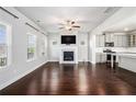 Spacious living room featuring a fireplace, hardwood floors, and an open layout to the kitchen with gray cabinets at 811 Corsiglia Farm, Marietta, GA 30060