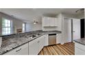 Kitchen showcasing stainless steel appliances, white cabinets, and granite countertops at 145 Charleston Pl, Covington, GA 30016