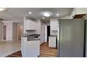 Well-lit kitchen with white cabinets, gray countertops and stainless-steel refrigerator at 145 Charleston Pl, Covington, GA 30016