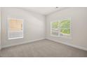 Bright bedroom featuring neutral carpet, trim, and natural light from two large windows at 5443 Blossomwood Sw Trl, Mableton, GA 30126