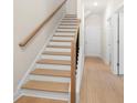 Beautiful stairway with wooden steps, white risers, and modern wood flooring leading to the upper level at 5443 Blossomwood Sw Trl, Mableton, GA 30126