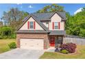 Charming two-story home with a stone accent garage, red shutters, and a landscaped front yard at 100 Cottage Nw Walk, Cartersville, GA 30121