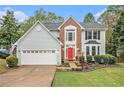 Charming two-story home with a red front door, gray siding, brick accent, a manicured lawn, and a two-car garage at 4272 Glenlake Nw Dr, Kennesaw, GA 30144