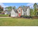Charming two-story home with a red front door, gray siding, brick accent, a manicured lawn, and a two-car garage at 4272 Glenlake Nw Dr, Kennesaw, GA 30144