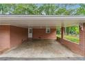 Attached brick carport offers protected parking with convenient access to the home's entrance at 851 Rockbridge Sw Rd, Lilburn, GA 30047