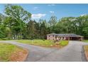 Inviting single-Gathering home featuring a brick exterior, mature trees, and a circular driveway for easy access at 851 Rockbridge Sw Rd, Lilburn, GA 30047