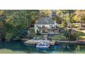 Scenic waterfront backyard with a private dock, boat, and multi-level deck perfect for entertaining and enjoying lake life at 10005 Lakeview Pkwy, Villa Rica, GA 30180