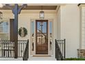 Elegant entryway features a dark wood door with glass panels, black iron railings and beautiful decorative accents at 3290 Camellia Ln, Suwanee, GA 30024