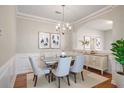 Elegant dining room with stylish chandelier, decorative molding and hardwood floors at 11151 Aliyah Dr, Hampton, GA 30228