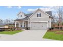 Charming home featuring a two-car garage, well-kept lawn and traditional architectural details at 214 Strawberry Ln, Woodstock, GA 30189