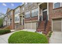 Inviting townhome row with manicured green shrubbery, stairs to a front porch, and garage at 346 Ardmore Ct, Atlanta, GA 30309