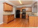 Kitchen featuring wood cabinets, black appliances, and hardwood floors at 3513 Brycewood Dr, Decatur, GA 30034