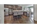 Modern kitchen featuring stainless steel appliances, dark wood cabinets, granite countertops, and a convenient breakfast bar area at 1510 Silver Mist Cir, Powder Springs, GA 30127