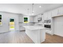 Spacious kitchen featuring white cabinets, a center island with quartz countertops, and stainless steel appliances at 3321 Burkston Pl, Buford, GA 30519