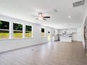 Open-concept living room and kitchen with abundant natural light from large windows overlooking the backyard at 3321 Burkston Pl, Buford, GA 30519