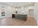 Modern kitchen featuring a large island, stainless steel appliances, and white cabinets at 80 White Spruce Trl, Dallas, GA 30157
