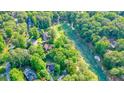 Aerial view of a home nestled among trees, near a golf course and winding river at 210 Malvern Pl, Roswell, GA 30076