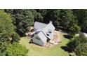 Aerial view of a home with an architectural roof design situated on a sprawling lot surrounded by lush greenery at 4392 Lower Fayetteville Rd, Sharpsburg, GA 30277