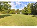 Expansive front yard featuring well-manicured lawn with a home nestled amongst mature trees in the background at 4392 Lower Fayetteville Rd, Sharpsburg, GA 30277