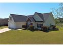 A well-maintained home with a lush green lawn and trimmed bushes is bathed in warm, natural sunlight at 502 Owens Springs Ln, Mcdonough, GA 30252