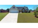Charming single-story home with a well-manicured lawn and a long driveway leading to an attached two-car garage at 502 Owens Springs Ln, Mcdonough, GA 30252