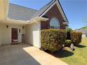Close up of front door, brick accent, and well maintained bushes and lawn at 502 Owens Springs Ln, Mcdonough, GA 30252