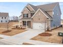 New construction home boasts a large driveway, attached garage, and a modern design with clean lines and neutral colors at 7164 Linden Dr, South Fulton, GA 30349