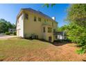 Back of home with a well-maintained lawn, a deck with railings, and double garage doors at 1820 Lyon Sw Ave, Atlanta, GA 30331