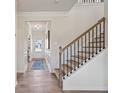 Hallway with beautiful hardwood floors, decorative wall trim, with view of stairs and front door at 26 Kensington St, Kingston, GA 30145