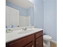 Well-lit bathroom featuring a vanity with dark wood cabinets, ample counter space, and a toilet at 3203 Cyrus Point Nw Ln, Kennesaw, GA 30152