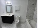 Modern bathroom features a tub and shower combo with stylish vanity and marble tile at 981 Dundee Dr, Lilburn, GA 30047