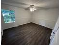 Bright bedroom features a ceiling fan, natural light, and sleek dark wood flooring at 981 Dundee Dr, Lilburn, GA 30047