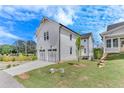 Two-story home with white siding and two car garage surrounded by green grass in a neighborhood at 1304 Six Sisters St, Dacula, GA 30019