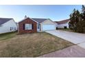 Inviting single-story home with a brick accent, attached garage, and a neatly landscaped front yard at 11447 Vinea Ln, Hampton, GA 30228