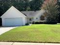 Close-up of charming single story home featuring an attached two car garage and well maintained lawn at 159 Parkside Dr, Stockbridge, GA 30281