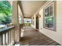 Inviting front porch with wooden flooring, brick pillars, and natural light at 3278 Shakerley Park, Douglasville, GA 30135