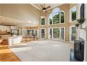 Bright living room boasts soaring ceilings, a fireplace, and large windows offering scenic views of the outdoors at 470 W Magnolia Cir, Johns Creek, GA 30005